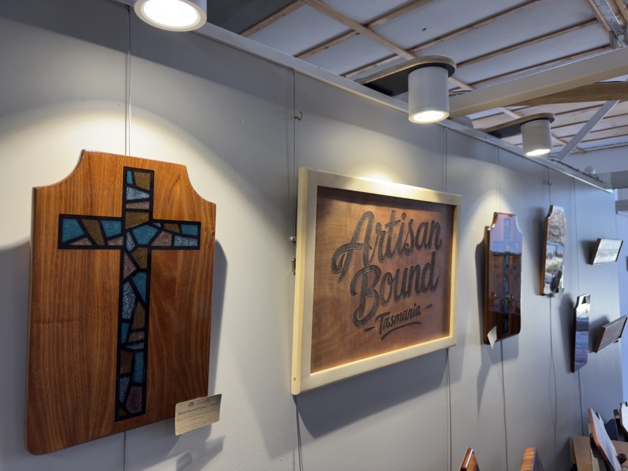Artisan Bound studio display featuring faceted epoxy cross and carved sign